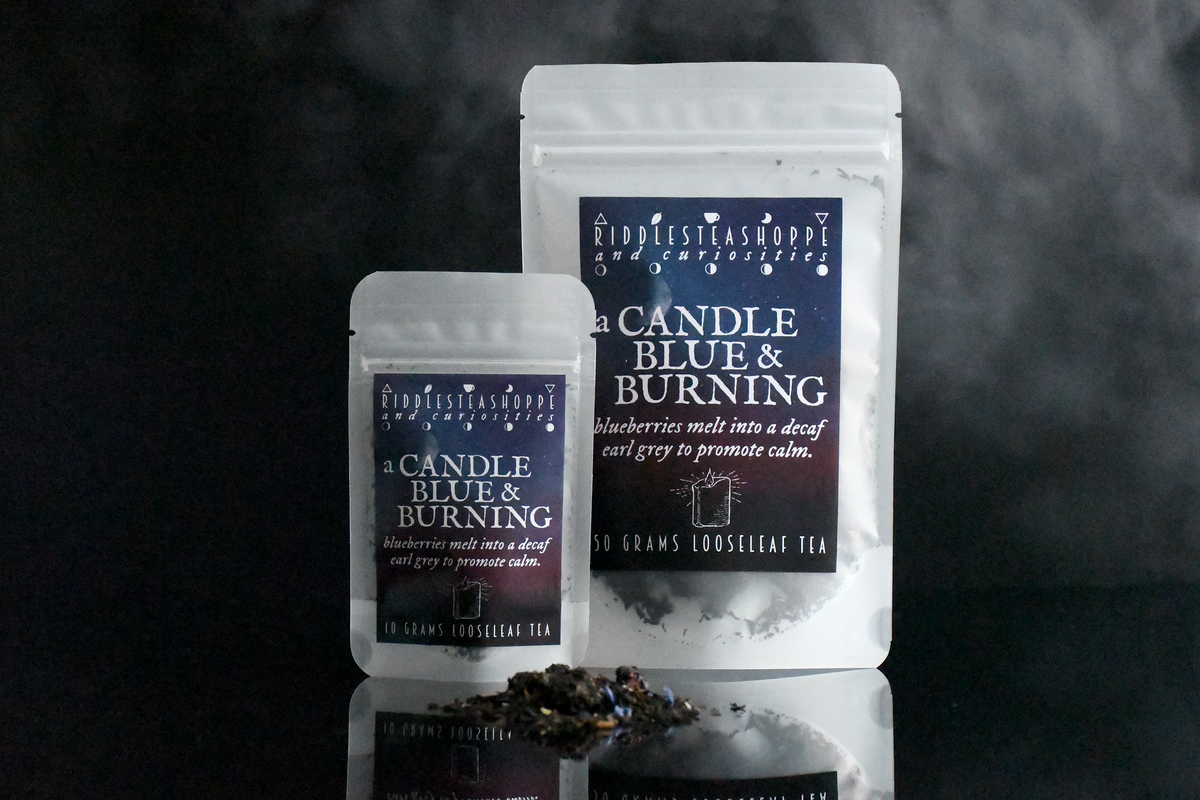 a Candle Blue & Burning Riddle's Tea Shoppe